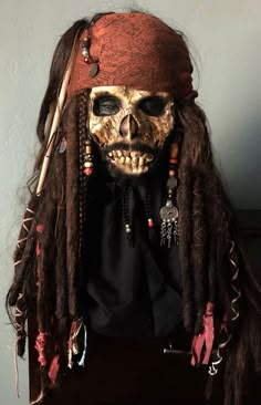 a skull with dreadlocks is wearing a pirate hat