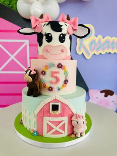 a birthday cake with a cow and farm animals on the top is decorated in pastel colors