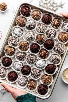 someone holding a tray full of chocolate truffles