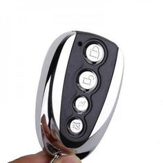 a hand holding a car key chain with the keys in it's holder,