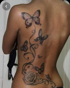 the back of a woman's body with butterflies and roses on her side,