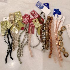 several bracelets are laid out on the counter top, including one with beads and two with charms