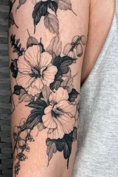 a woman's arm with black and white flowers on it