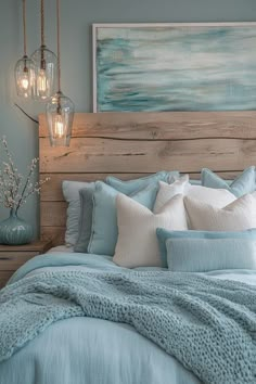 a bed with blue and white comforters in a bedroom next to a painting on the wall