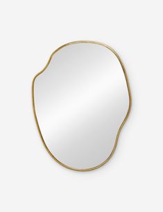 an oval mirror with gold frame on a white wall, it is placed in the shape of a leaf