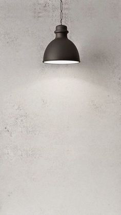 a black lamp hanging from the ceiling in a room with concrete walls and flooring