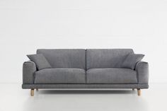 a gray couch sitting on top of a white floor