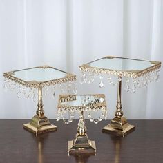 two gold colored candlesticks on a wooden table