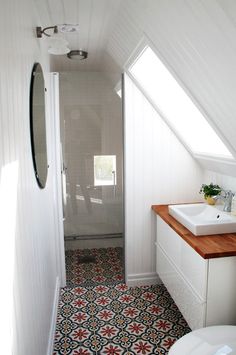 a bathroom with a sink, toilet and shower in it's stall next to a window