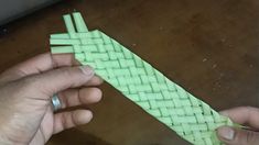 a person holding a piece of green woven material