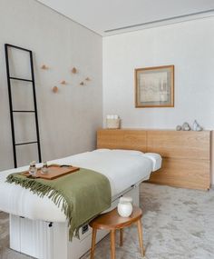 a white bed sitting next to a wooden dresser in a bedroom on top of carpet