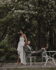 a bride and groom pose for a photo in front of a table with white chairs