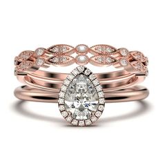 two rose gold wedding rings with a pear shaped diamond in the center and an intricate band