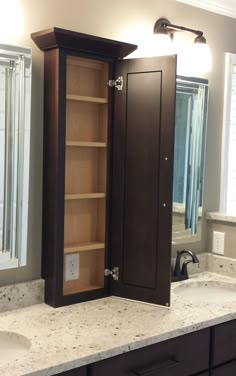 a bathroom with a double sink and open cabinet in the middle on top of it