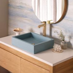 a bathroom sink with a mirror above it and a blue box on the counter top