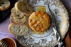 a plate with bread and butter on it next to a cup of tea or coffee