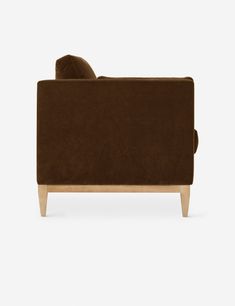 a brown couch sitting on top of a white floor next to a wooden frame and legs