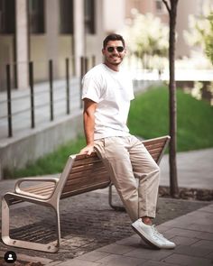 a man sitting on top of a wooden bench