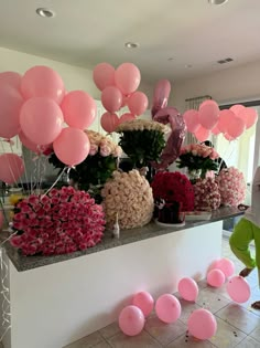 pink balloons and flowers are on display at a party