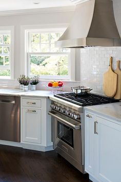 a kitchen with white cabinets and stainless steel appliances