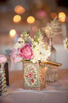 there is a vase with flowers in it on the table next to candles and other decorations