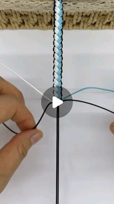 two hands are working on a piece of string