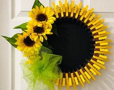 a sunflower wreath on the front door is decorated with yellow sticks and tulle