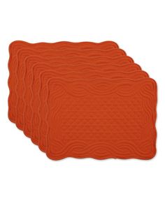 four orange placemats with wavy designs on each side and one in the middle