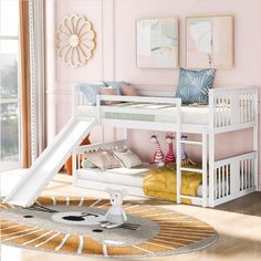 a white bunk bed with a slide on the bottom and pink walls in the background