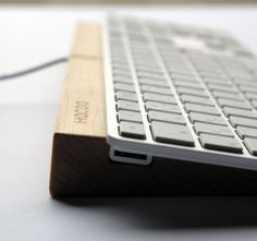 a white keyboard sitting on top of a wooden stand