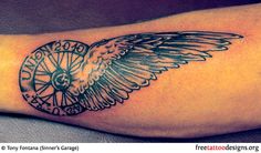 a black and white tattoo on the arm of a person with an owl compass in it