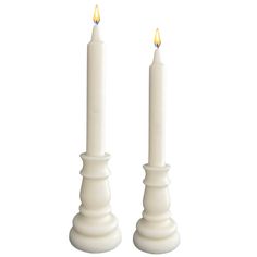 two white candles sitting next to each other