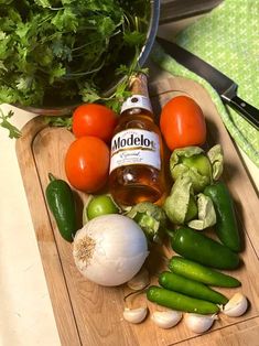 some vegetables are sitting on a cutting board next to a bottle of alcohol and knifes