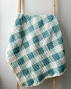 a blue and white checkered blanket hanging on a wall