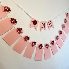 a pink banner that says n e with ladybugs hanging from it's sides