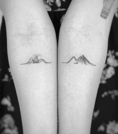 two small tattoos on both legs with mountains in the middle and clouds above them,