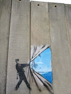 a piece of art on the side of a wooden wall with a painting of a man holding a kite