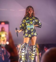 a woman standing on top of a stage wearing rollerblades and holding a microphone