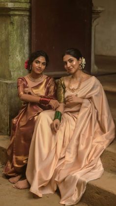 two women sitting next to each other on steps