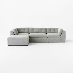 a large sectional couch with a footstool on the bottom and one end facing it