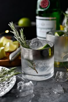 two glasses filled with ice and some limes