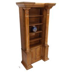 a wooden bookcase with two blue vases on the top and bottom shelves in front of it