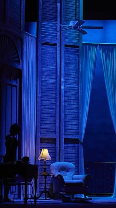 a living room filled with furniture next to a tall building in the dark blue light