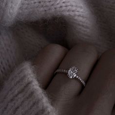 a woman's hand with a diamond ring on it