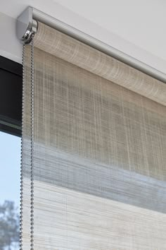 a close up of a window with a curtain on it's side and the blinds closed