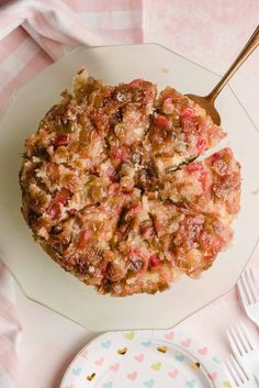 a white plate topped with a pizza covered in toppings next to a pink and blue polka dot table cloth