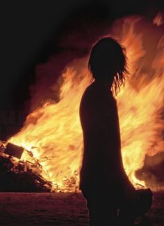 a person standing in front of a large fire