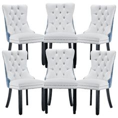 six white dining chairs with black legs and buttons on the back, set of 6