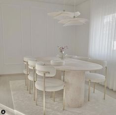 a dining room table with white chairs around it