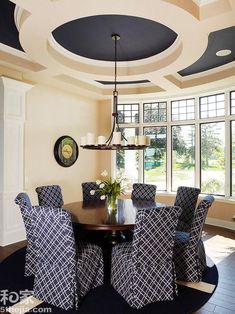 a dinning room table with blue chairs and a chandelier hanging from the ceiling